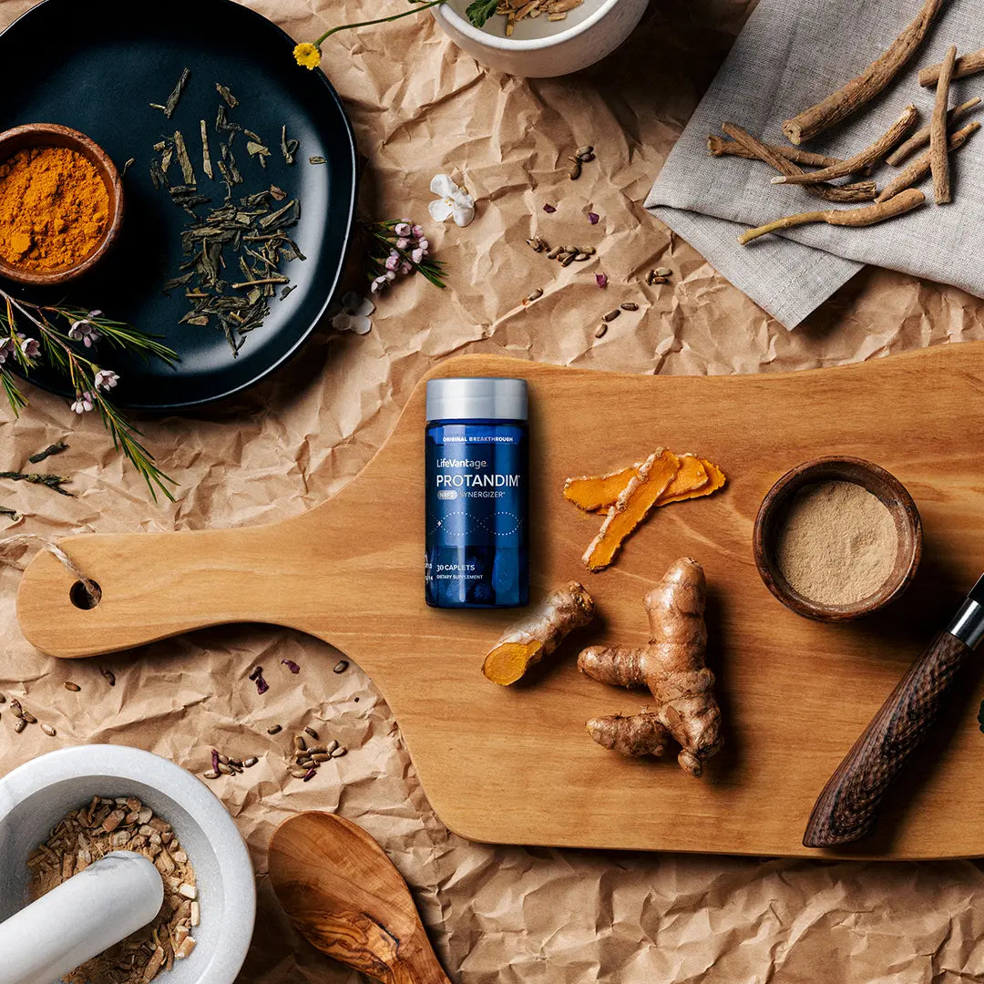 Protandim NRF2 supplement with herbal ingredients turmeric ginger and plant extracts on wooden board