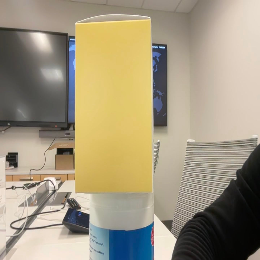Yellow cube in front of a TV screen in an office setting